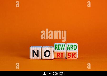 No risk or reward symbol. Turned cubes and changed words 'no risk' to 'no reward'. Beautiful orange background. No risk or reward and business concept Stock Photo