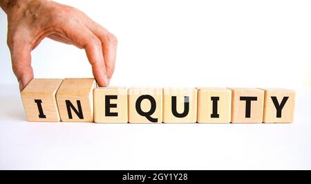 Inequity or equity symbol. Businessman turns wooden cubes and changes the word inequity to equity. Business and inequity or equity concept. Beautiful Stock Photo