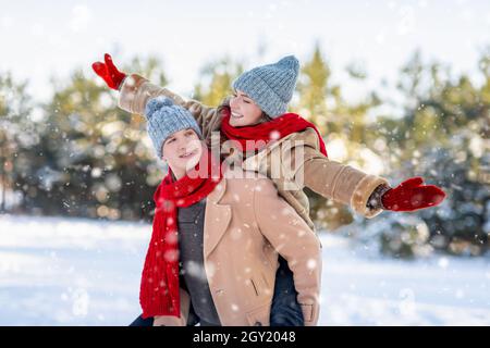 Carefree loving hipsters enjoying snowy winter day at park Stock Photo