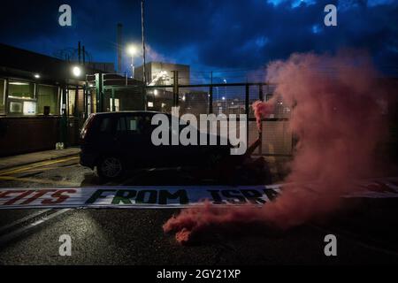 Sandwich, UK. 4th October, 2021. Two Palestine Action activists with smoke grenades are pictured locked onto a car to block an entrance to the Instro Precision factory in Discovery Park. Instro Precision is a subsidiary of Elbit Systems, Israel's largest publicly-traded arms company, and supplies 'high precision military equipment' which Palestine Action contends has been used by the Israeli military against the population of Gaza. Credit: Mark Kerrison/Alamy Live News Stock Photo