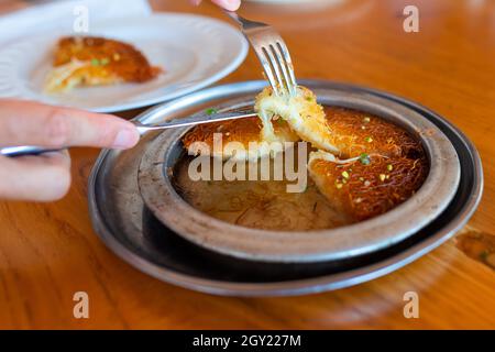 Turkish dessert kunefe, kunafa, kadayif with pistachio powder and cheese, served hot, very sweet. Turkish traditional dessert Stock Photo