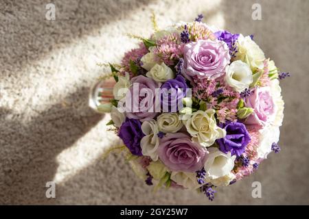 bride's bouquet with blue, pink, white and green roses, and also lavender Stock Photo