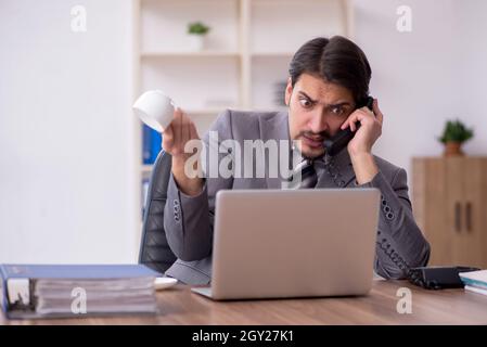 Young businessman employee drinking coffee during break Stock Photo