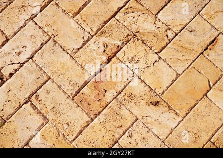 Yellow brown stone pavers background. Neutral texture of a flat brick wall close-up. Stock Photo
