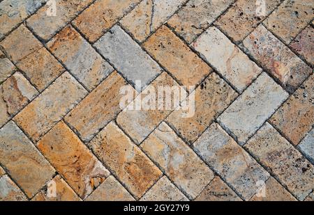 Yellow brown stone pavers background. Neutral texture of a flat brick wall close-up. Stock Photo