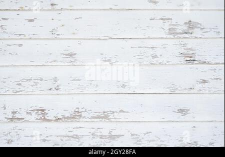 Crackled paint finish on white wood planks. Aged reclaimed barn wood. White antique faded rough wood surface. Stock Photo