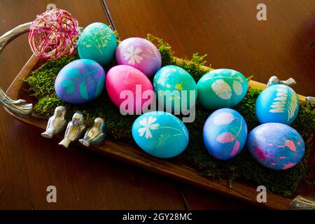 Colorful pastel easter eggs in a basket filled with fake moss Stock Photo