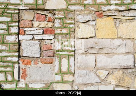 Stone background with a red square amidst green-lined stones Stock Photo