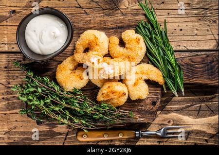 Fried Crispy Shrimps Prawns on a wooden board with sauce. wooden background. Top view Stock Photo