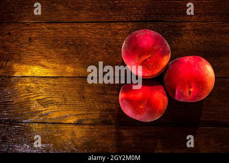 Top view shot of fresh juicy peaches on a rustic wooden table Stock Photo