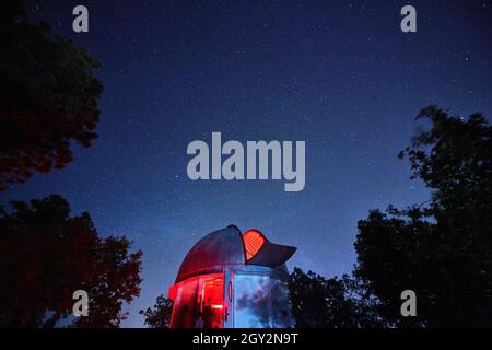 Observatory open to the night sky with red light coming from it ominous Stock Photo