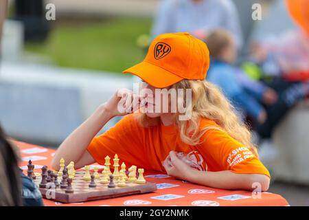 Pensive woman sitting at table in living room while thinking about next  chess move. Stock Photo by DC_Studio