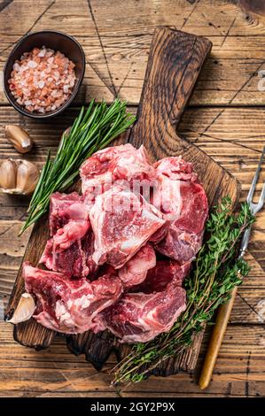 https://l450v.alamy.com/450v/2gy2p9x/raw-beef-meat-diced-for-stew-with-bone-wooden-background-top-view-2gy2p9x.jpg