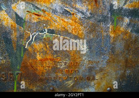 Rusty old metal plaque with letters and numbers embossed on it background Stock Photo