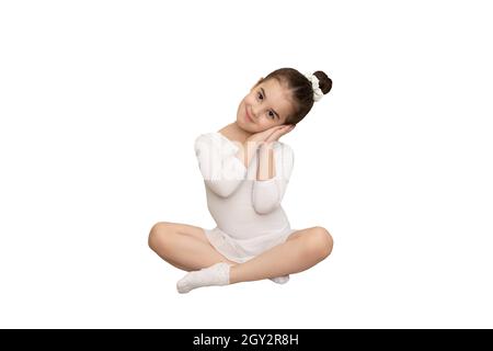 little girl sits in a white dance swimsuit Stock Photo