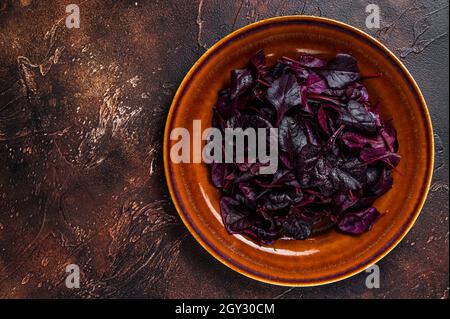 Raw Ruby or red chard salad Leafs on a rustic plate. Dark background. Top view. Copy space Stock Photo