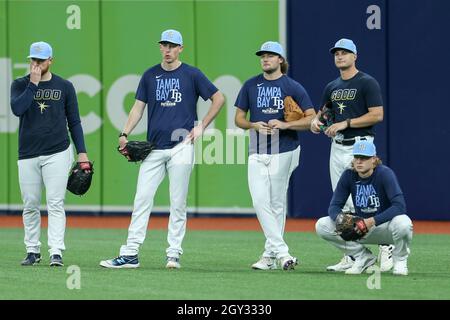 Tampa Bay Rays pitchers Josh Fleming, left to right, Zach Eflin and Shane  McClanahan laugh in the dugout after watching infielder Luke Raley pitch  during a baseball game against the Toronto Blue