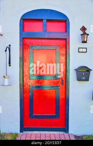 Old style red and black door on white wall Stock Photo