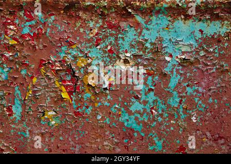 Old abandoned wall with peeling red and yellow paint background Stock Photo