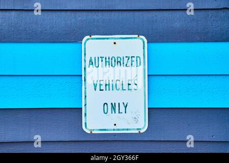 Wood panels painted blue with sign reading Authorized Vehicles Only Stock Photo
