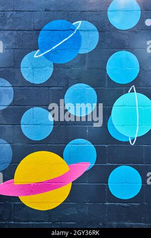 Cement wall painted with black and blue spots and planets Stock Photo