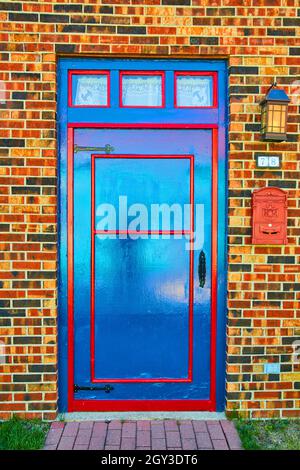 Old style blue and red door on brick Stock Photo