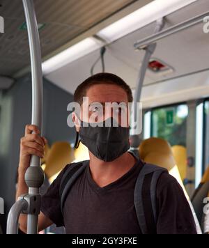 Young Caucasian male with a protective mask making fun of a sign by ...