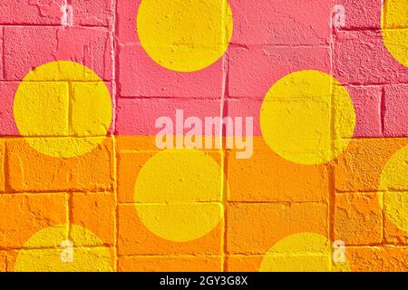 Cement wall straight on divided by pink and orange with circles of yellow Stock Photo