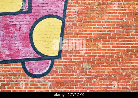 Wall of textured red brick with graffiti Stock Photo