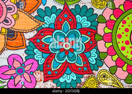 View of brick wall with beautiful colorful flowers painted Stock Photo