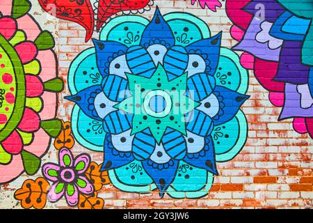 Brick wall with mural of colorful flower patterns Stock Photo