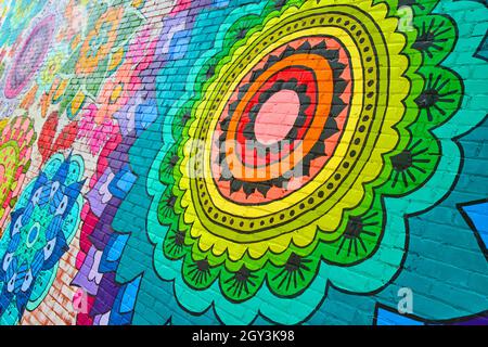 Rainbow flower painting mural on brick wall Stock Photo