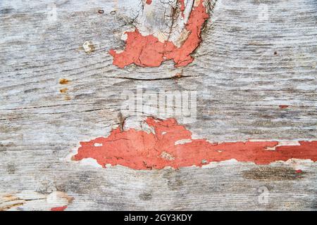 Orange paint peeling off of wood texture up close Stock Photo