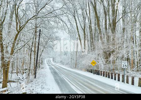 Road through winter road with trees covered in snow Stock Photo