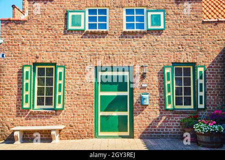 Dutch architecture with green and yellow doors and shutters on red brick Stock Photo