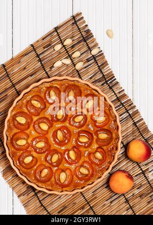 Top view of homemade delicious apricot tart with almond nuts. Sweet food concept. Copy space. Stock Photo
