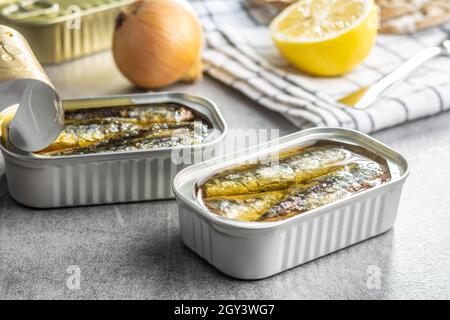 Canned sardines. Sea fish in tin can on kitchen table. Stock Photo