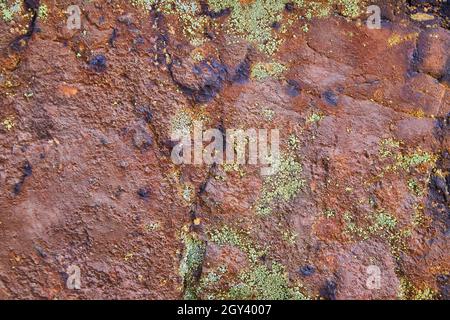 Texture of rock wall of red with patches of lichen Stock Photo