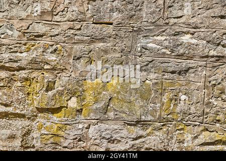 Detail texture of wall of stone with faint green lichen Stock Photo