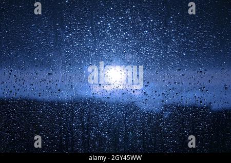 Blue water drops on the window pane. Stock Photo