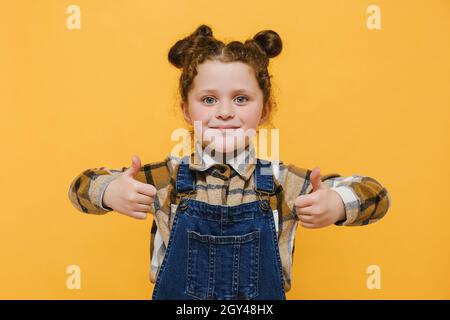Close-up portrait of her she nice adorable lovely sweet attractive cheerful cheery straight-haired blonde pre-teen girl opened mouth showing thumb up Stock Photo