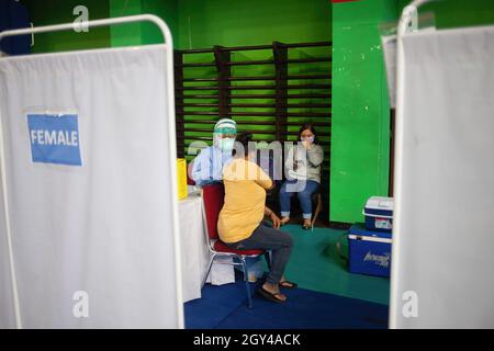 A health worker administers a first dose of Sinopharm COVID-19 vaccine to an Asylum seeker at the Bulungan Sports Center, South Jakarta. As many as 600 asylum seekers in Jakarta registered to receive the first dose of vaccine. The government is targeting 7000 asylum seekers to get the first dose of vaccine to continue to suppress the transmission of Covid-19 in Indonesia. (Photo by Edy Susanto / SOPA Images/Sipa USA) Stock Photo