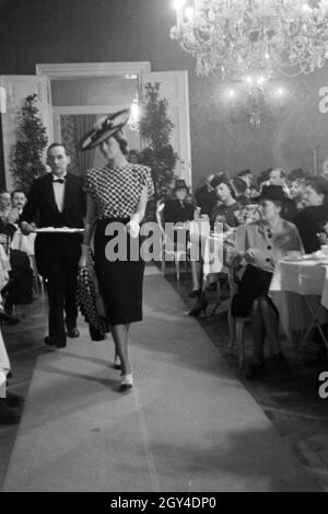 Anlässlich der Wiener Modewoche im Haus der Mode "Palais Lobkowitz" präsentiert ein Model auf dem Laufsteeg eine neue Kombination, Deutschland 1940er Jahre. On the occasion of the Vienna fashion week in the house of fashion "Palais Lobkowitz", a model is presenting a new combination on the catwalk; Germany 1940s. Stock Photo