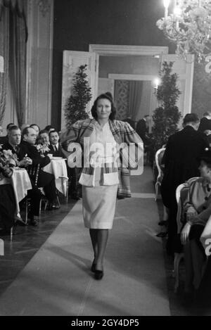 Anlässlich der Wiener Modewoche im Haus der Mode "Palais Lobkowitz" präsentiert ein Model auf dem Laufsteeg eine neue Kombination, Deutschland 1940er Jahre. On the occasion of the Vienna fashion week in the house of fashion "Palais Lobkowitz", a model is presenting a new combination on the catwalk; Germany 1940s. Stock Photo