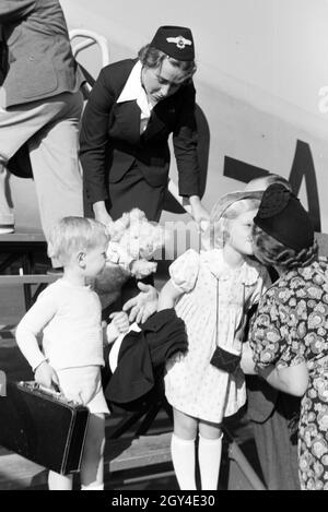 Stewardess hilft Kindern bei der Ankunft / Verabschiedung / beim ...