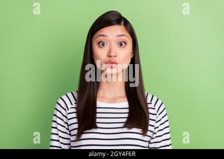 Photo of flirty brunette millennial lady blow kiss wear striped shirt isolated on green color background Stock Photo