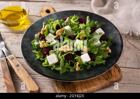 Beetroot salad with feta cheese,lettuce and walnuts on wooden table Stock Photo