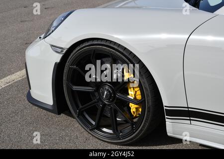 Mugello Circuit, Italy - 23 September 2021: detail of an alloy wheel rim with yellow brake caliper of a Porsche 911 in the paddock of Mugello Circuit. Stock Photo