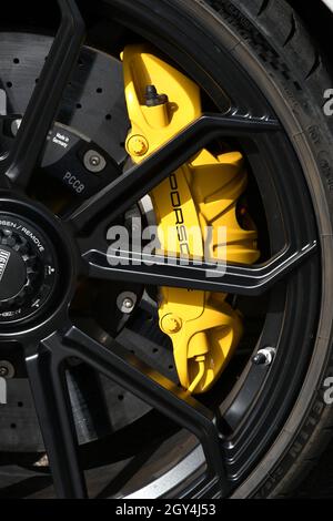 Mugello Circuit, Italy - 23 September 2021: detail of an alloy wheel rim with yellow brake caliper of a Porsche 911 in the paddock of Mugello Circuit. Stock Photo