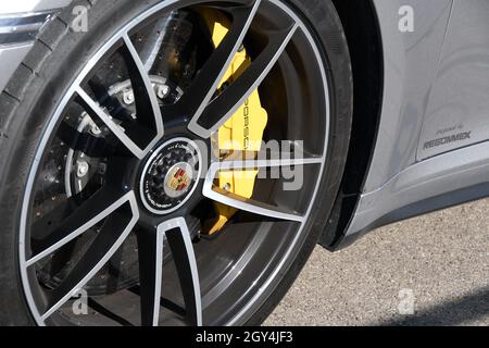 Mugello Circuit, Italy - 23 September 2021: detail of an alloy wheel rim with yellow brake caliper of a Porsche 911 in the paddock of Mugello Circuit. Stock Photo